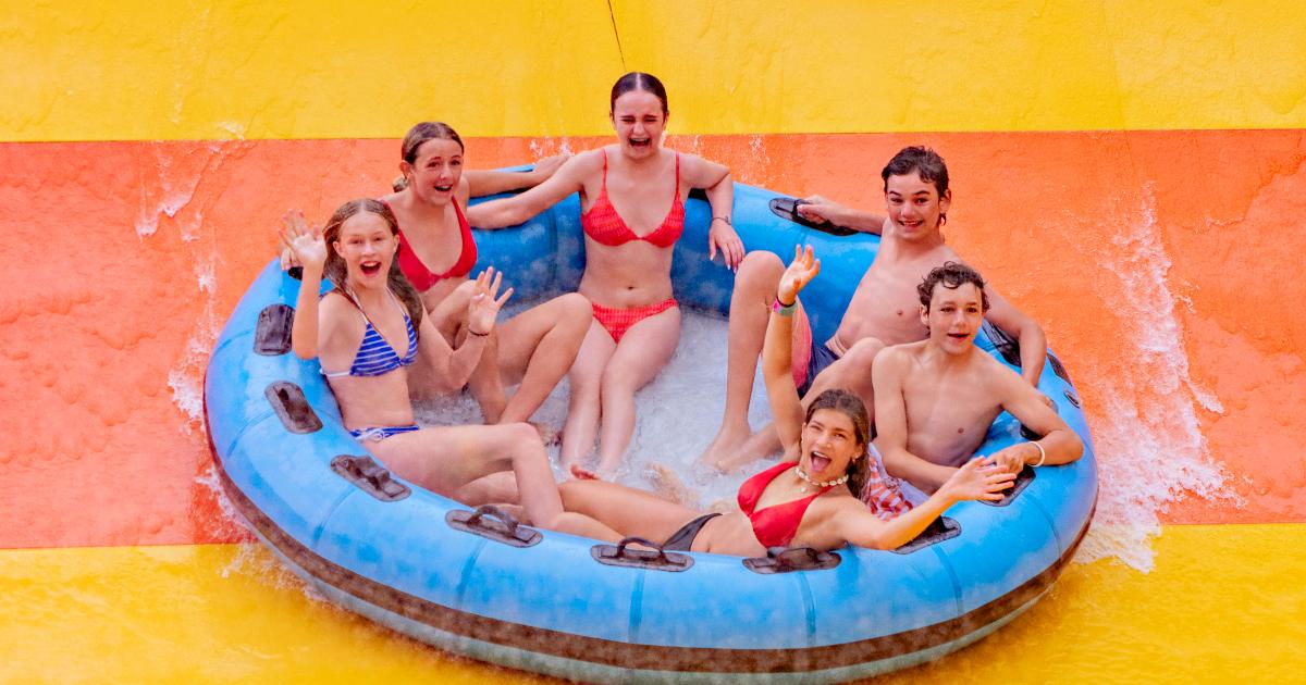 Four at top of slide in family raft